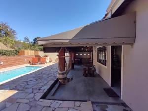a building with an awning next to a swimming pool at Um lugar para descansar e relaxar in Serra Negra