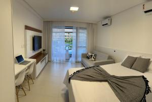 um quarto com 2 camas, uma secretária e um sofá em Flat com vista linda Eco Resort em Tamandaré