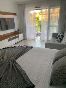 a living room with a large bed and a couch at Flat com vista linda Eco Resort in Tamandaré