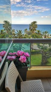 - un balcon avec vue sur l'océan et les fleurs dans l'établissement CANNES Front de Mer - Appartement 3 STAR, à Cannes