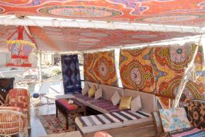 um sofá debaixo de uma tenda com um tecto colorido em Misteri em Esna