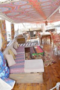 uma sala de estar com sofás e mesas num barco em Misteri em Esna