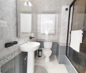 y baño con aseo, lavabo y espejo. en HABITACION 1 independiente baño y balcón privado, en Bogotá