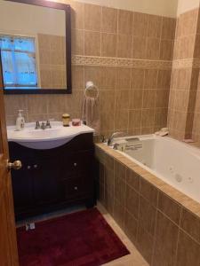 een badkamer met een wastafel, een bad en een spiegel bij The Escape in Fond Cani