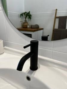 a bathroom sink with a black faucet and a mirror at Newly refurbished, coastal apartment- Barbati in Barbati