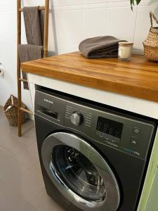 y cocina con lavadora y encimera de madera. en Newly refurbished, coastal apartment- Barbati en Barbati