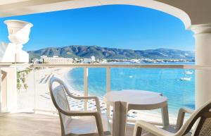 einen Balkon mit einem Tisch und Stühlen sowie Meerblick in der Unterkunft Seramar Hotel Comodoro Playa in Palmanova