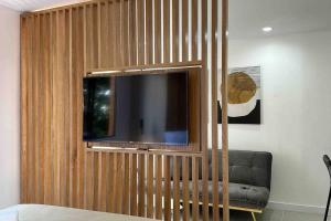 - une télévision sur un mur en bois dans le salon dans l'établissement Exclusivo Loft en el poblado-rodeado de naturaleza 501, à Medellín
