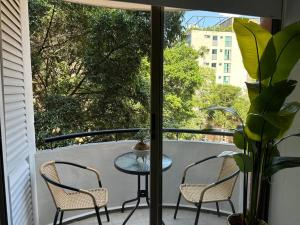 une table et deux chaises sur un balcon avec vue dans l'établissement Exclusivo Loft en el poblado-rodeado de naturaleza 501, à Medellín