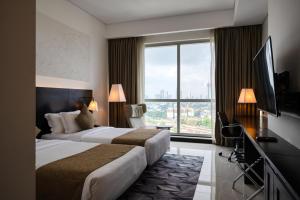 a hotel room with two beds and a large window at Orion City Hotel in Colombo