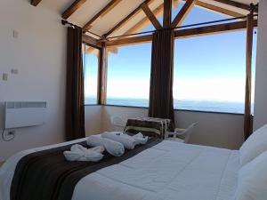 a bedroom with a large bed with a large window at Sol y Luna ISLA DEL SOL in Comunidad Yumani