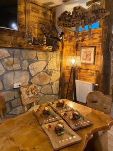 a wooden table with two plates of food on it at HotelRestaurant Gështenja in Suharekë