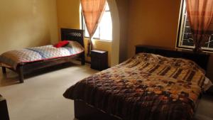 1 dormitorio con cama y ventana en Hostel Del Piamonte 2, en Quito