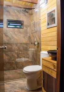 a bathroom with a toilet and a glass shower at Mia`s cabañas in Rionegro
