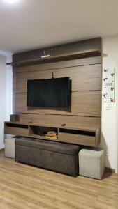 sala de estar con TV de pantalla plana en la pared en Centro de Gramado, en Gramado
