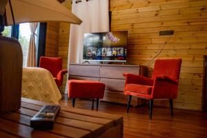 a living room with red chairs and a tv at Mia`s cabañas in Rionegro