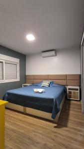Un dormitorio con una cama con un edredón azul. en Centro de Gramado, en Gramado