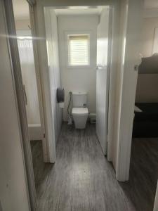 a small bathroom with a toilet and a window at Glenwood Tourist Park & Motel in Grafton