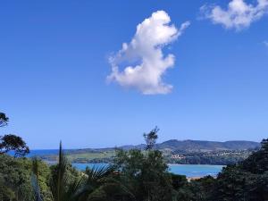 una vista de un cuerpo de agua con una nube en el cielo en Le Moubin en La Trinité
