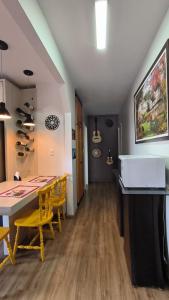 una sala da pranzo con tavolo e sedie gialle di Centro de Gramado a Gramado