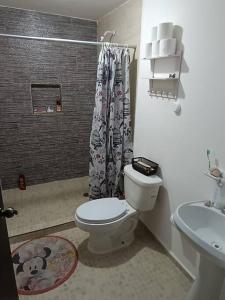 a bathroom with a toilet and a sink at Luxos Casa Residencial Privada 