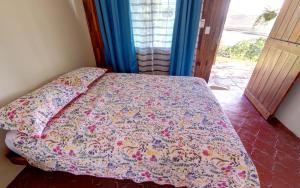 a bedroom with a bed with a flowered bedspread at Vista Lago Arenal in Piedras +21 photos