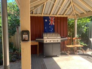 a patio with a grill with a flag on it at lovey studio with bathroom and kitchen in Perth