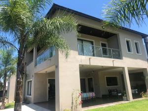 una casa con palmeras delante en San Lorenzo Premium en San Lorenzo