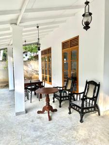 Pokój z krzesłami oraz drewnianym stołem i krzesłami w obiekcie ALOHA Second Home w Tangalli