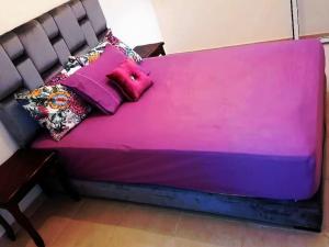 a purple bed with pillows on it in a room at joli appartement près de la mer in Casablanca