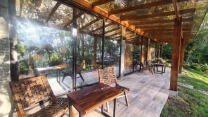 a screened in porch with two chairs and a table at UMA Experience in Coroico