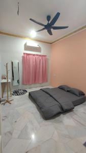 1 dormitorio con 1 cama y ventilador de techo en BRICK HOMESTAY en Teluk Intan