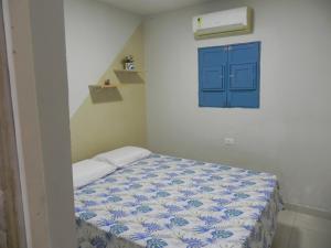 a small room with a bed with a blue door at Casa Paraiso Maragogi in Maragogi