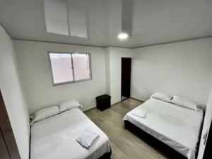 Cette chambre comprend 2 lits et une fenêtre. dans l'établissement APARTAMENTOS SUPER PENTHOUSE con BALCÓN, à El Colegio