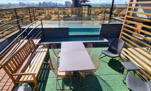 a table and chairs on a balcony with a pool at Reserva Madero Requinte Apto 104 in Natal