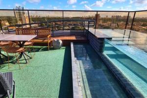 a swimming pool on top of a building at Reserva Madero Requinte Apto 104 in Natal