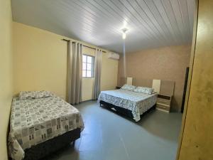 een kamer met 2 bedden en een raam erin bij Casa Grande com 2 quartos e 1 suíte in Foz do Iguaçu
