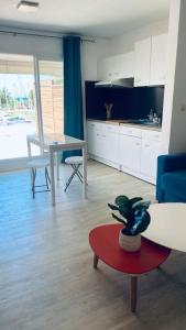 a living room with a couch and a table with a plant at Marin’Appart * vue sur mer* in Gourbeyre