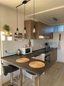 a kitchen with a table with two chairs and a microwave at GOLDEN HOUR Beachfront apartment Marbella in Marbella