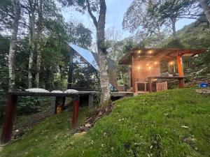 uma pequena casa na floresta com uma tenda em UMA Experience em Coroico