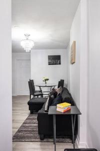 uma sala de estar com um sofá preto e uma mesa em Harmony Home Near University of Waterloo em Waterloo