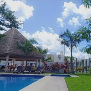 una piscina con sillas y un cenador en Hermosa casa en privada en Cancún