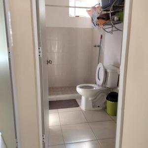 baño blanco con aseo y ventana en Hermosa casa en privada en Cancún