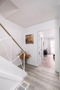 a white hallway with a staircase in a house at Harmony Home Near University of Waterloo in Waterloo