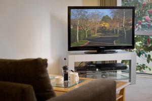 een flatscreen-tv zittend op een witte tafel bij Park Avenue - Forest Hill in Forest Hill