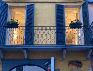 a balcony with blue shutters and flowers on it at Casa Roveglia in Brescia