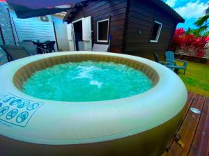 a large hot tub in front of a house at Bungalow Ti Kako in Capesterre-Belle-Eau
