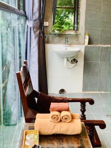 uma casa de banho com uma cadeira ao lado de um lavatório em Mường Retreat- Nghỉ dưỡng xanh trong Bảo tàng Văn hóa Nghệ thuật,Hòa Bình em Quỳnh Lâm