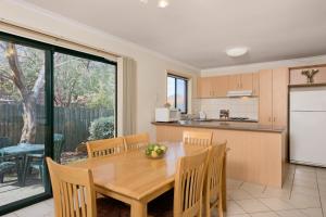 een keuken en eetkamer met een houten tafel bij Park Avenue - Forest Hill in Forest Hill