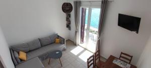 a living room with a couch and a television at Flisvos Apartments in Tinos Town